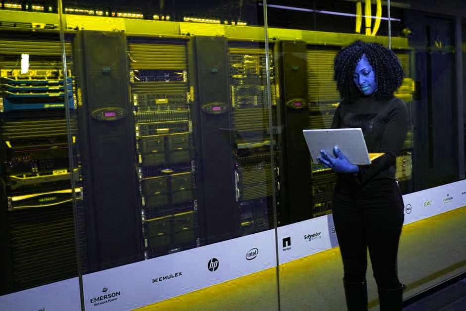 Ingénieure devant un ordinateur portable dans une salle serveurs.