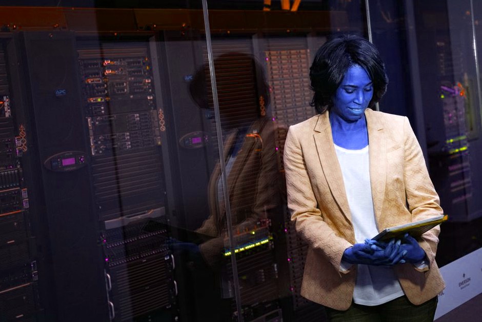Professionnelle IT inspectant des serveurs dans un datacenter.